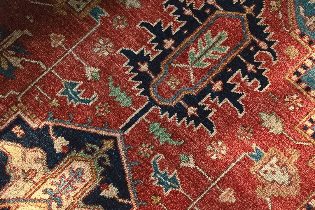 Red hand-knotted rug with navy and ivory motifs