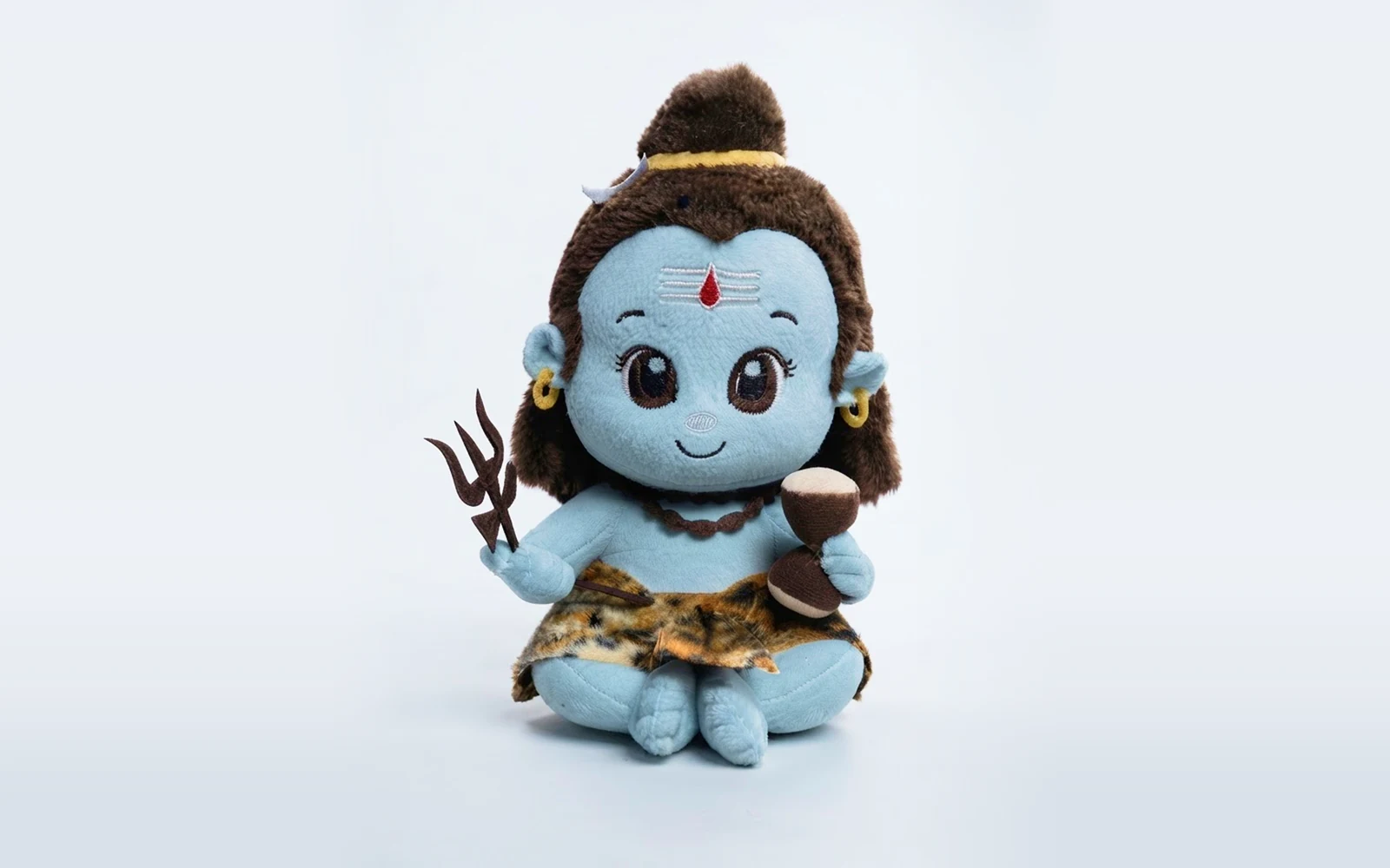 Blue Lord Shiva plush toy holding a trishul and damru